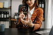 © Nuttapong punna - Woman working with laptop computer and smart phone on desk in modern office with virtual icon diagram