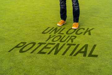 Man standing on the  synthetic grass turf with a motivational quote written, Unlock Your Potential