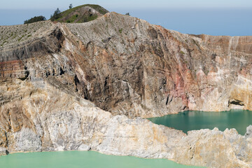 two volcanic craters filled with different colored water at kelimutu, indonesia.