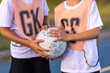 © Austockphoto - detail of two children holding netball