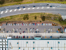 overhead view of highway beside busy hardware store with car parking