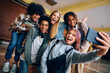 © Drazen - Multiracial group of cheerful teenage friends taking selfie at high school.