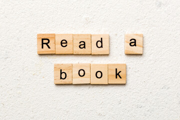 Wall Mural - read a book word written on wood block. read a book text on table, concept