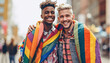 © annebel146 - Portrait of young gay,lesbian couple embracing and showing their love with rainbow flag at the street. LGBTQ and love concept.