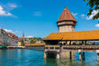 Lovely close-up view of the famous covered timber footbridge, the Kapellbrücke (Chapel Bridge), spanning the river Reuss diagonally in the city of Lucerne together with the Water Tower.  