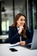© bnenin - A pretty female employee having an online meeting with a client over a laptop.