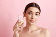 © master1305 - Beautiful young woman with healthy, well-kept skin taking care after health, drinking water with lemons against pink studio background. Concept of natural female beauty, body and skincare, health, ad