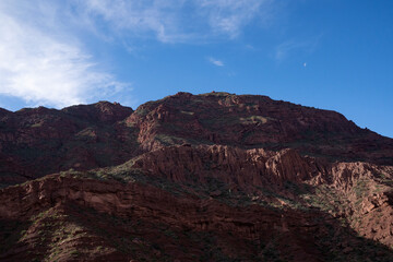 Wall Mural - Panorama view of the brown rocky mountain peak and cliffs in the desert, under a blue sky.