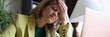 © megaflopp - Overworked woman sitting in office and touching head with hand