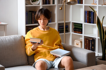 Poster - Teenage boy with books sitting on sofa at home