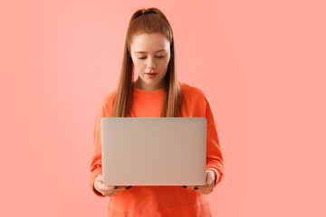 Female programmer with laptop on pink background