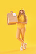 © Pixel-Shot - Female courier with paper bags on yellow background