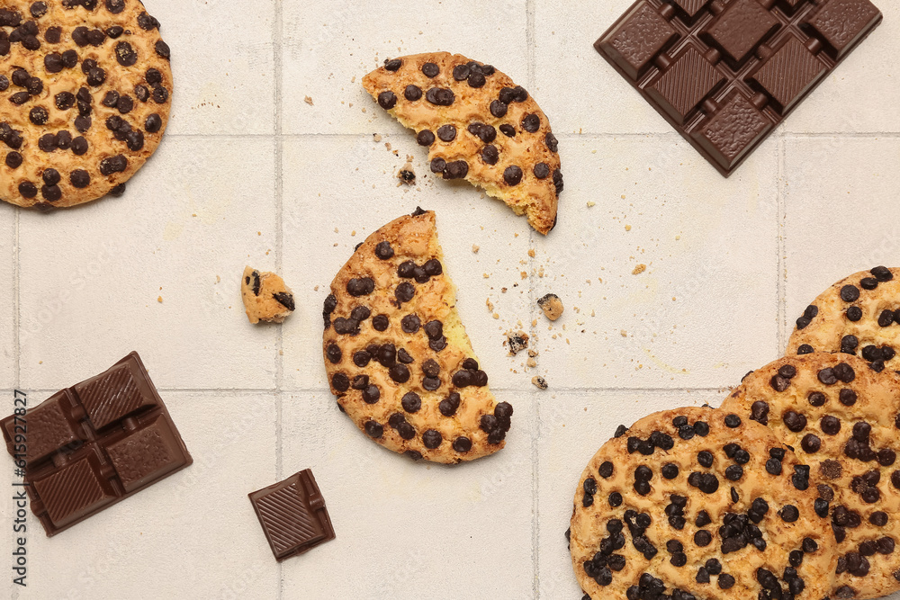 Cookies and chocolate on white tile background