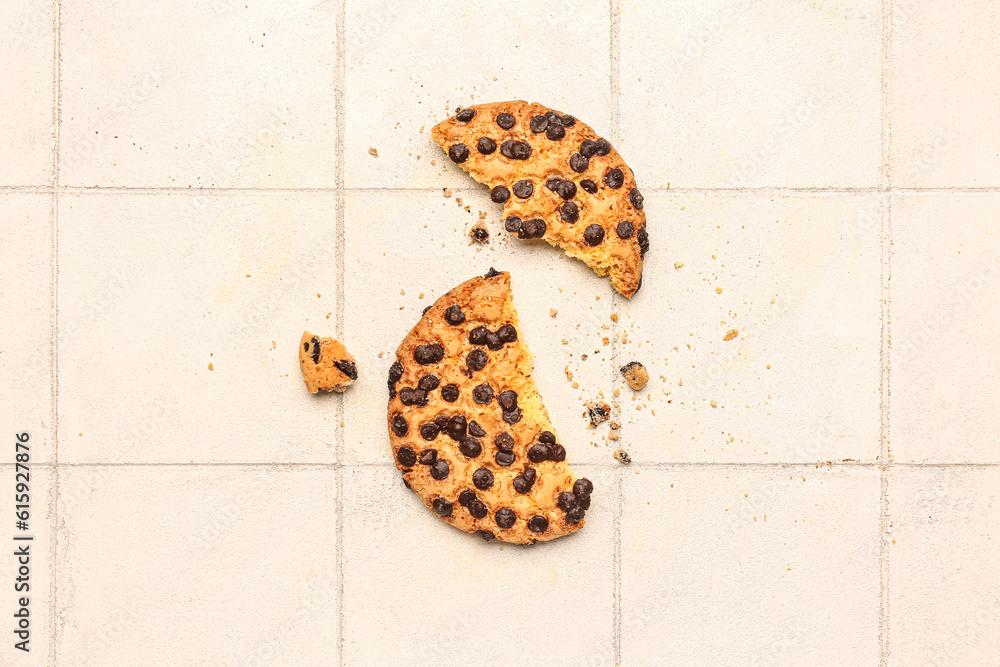 Broken cookie on white tile background
