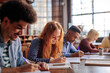 © bernardbodo - Students study together in school library.
