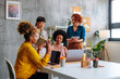 © bernardbodo - Business group of four diverse women having meeting in startup office.