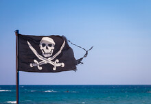 A Damaged Pirate Flag During A Strong Windy Day, With Copyspace