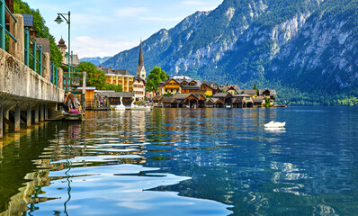 Wall Mural - Hallstatt, Austria. Lake Hallstattersee with calm blue water among austrian Alps mountains. Embankment of antique picturesque town. View to old houses on coast and chapel of church.