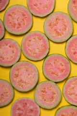 Sticker - top view of slices of pink guava on yellow background