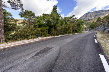 Sticker - Asphalt road between forests in Provence-Alpes-Cote d Azur region in southeastern France.