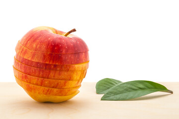 Wall Mural - apple preserved its shape, but cut into slices on a wooden table.