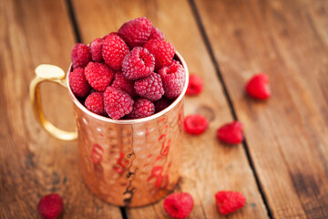 Wall Mural - Fresh ripe raspberries in a copper mug