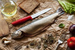 Fresh trout fish with spices and ingredients ready to cook on brown crumpled wrapping paper