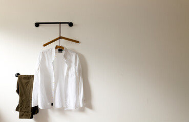 Wall Mural - White shirt and pants hanging against white wall