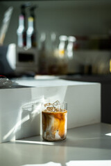 Wall Mural - Iced coffee with ice cubes in a glass on the table