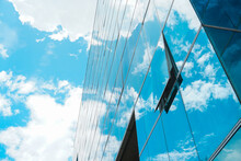 Open Window Glass In A Multi-story Building Reflecting The Enchanting Cloudy Blue Sky
