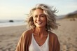 © Adriana - Smiling attractive beautiful caucasian senior mature woman posing at the beach looking at the camera