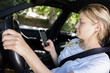 © auremar - young woman texting while driving her car