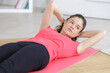 © auremar - young woman exercising at home on a mat