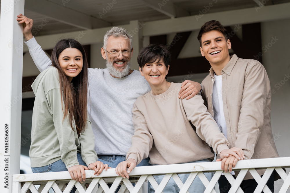 Portrait of positive middle aged parents looking at camera while ...