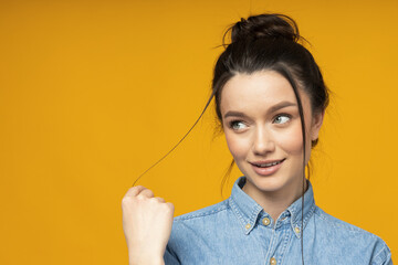 Poster - A young woman in a denim shirt with her hair tied up,place for text