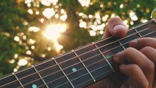 Playing Guitar In The Sunset. Sun Rays On Guitar Strings. Music Sounds On Guitar Strings