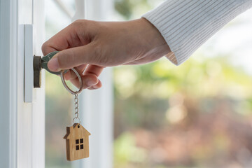 Wall Mural - Landlord key for unlocking house is plugged into the door. Second hand house for rent and sale. keychain is blowing in the wind. mortgage for new home, buy, sell, renovate, investment, owner, estate