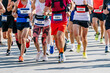 large group runners athletes men and women run city marathon race, numbers on shirts, summer sports games