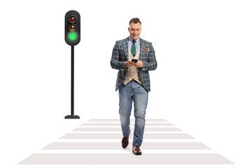 Canvas Print - Full length portrait of a man in a stylish suit and jeans crossing a street and using a smartphone