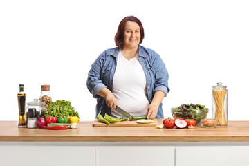 Canvas Print - Casual woman cutting vegetables on a kitchen counter and preparing a salad