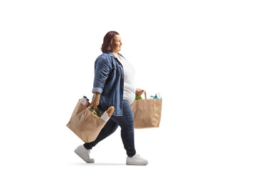 Poster - Full length profile shot of a corpulent woman carrying grocery bags and walking