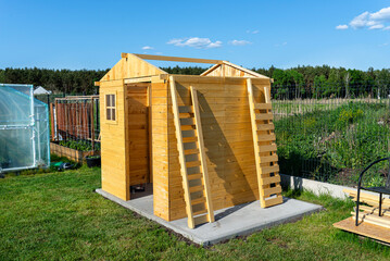 Wall Mural - A wooden garden shed under construction standing on a concrete foundation in the garden.