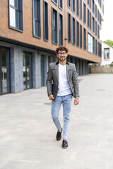 Wall Mural - Confident smiling businessman wearing white shirt holding laptop looking away on urban street. Successful business