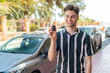 © luismolinero - Young handsome man holding car keys at outdoors with happy expression