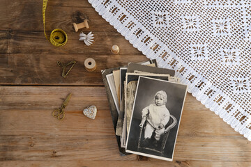 old vintage monochrome photographs scattered on rustic wooden table, dear to heart memorabilia, decor, concept family tree, genealogy, childhood memories, retro inspiration, old-fashioned charm