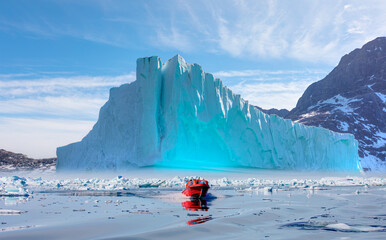 Wall Mural - fast moving motorboat trying to get out of the ice - stranded icebergs in the fog at the mouth of th