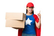 © luismolinero - Super Hero delivery Asian woman holding boxes over isolated background showing and lifting a finger in sign of the best