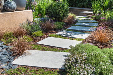 Path with large stone slabs through a beautifully planted garden