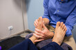 © Austockphoto - Physiotherapist at work in clinic with client giving feet a massage