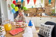 © luckybusiness - Grandma's Joyful Birthday Celebration with Cake at the Table in Kitchen